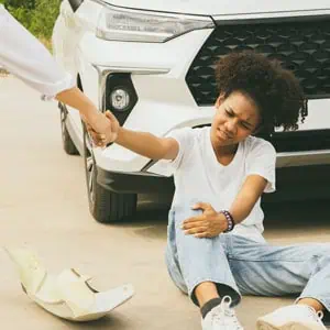 Person sitting on the ground after a Pedestrian Accident