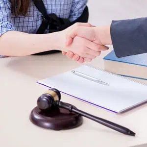 Handshake between lawyer and injured client discussing a car accident lawsuit in Louisiana.